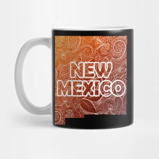 Colorful mandala art map of New Mexico with text in brown and orange Mug